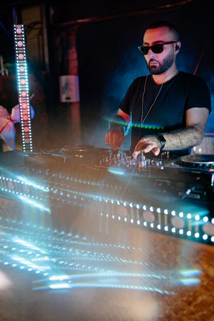 Energetic DJ mixing music at a vibrant nightclub with colorful lights.