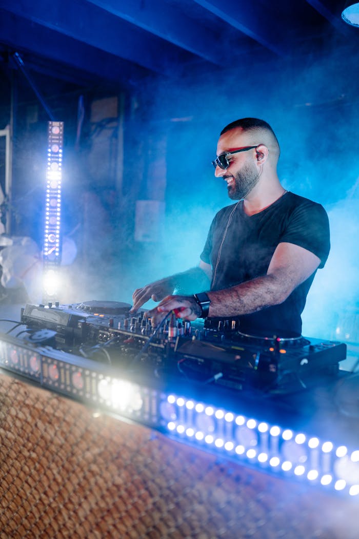 Energetic DJ playing music at a nightclub with vibrant lighting and smoke effects.